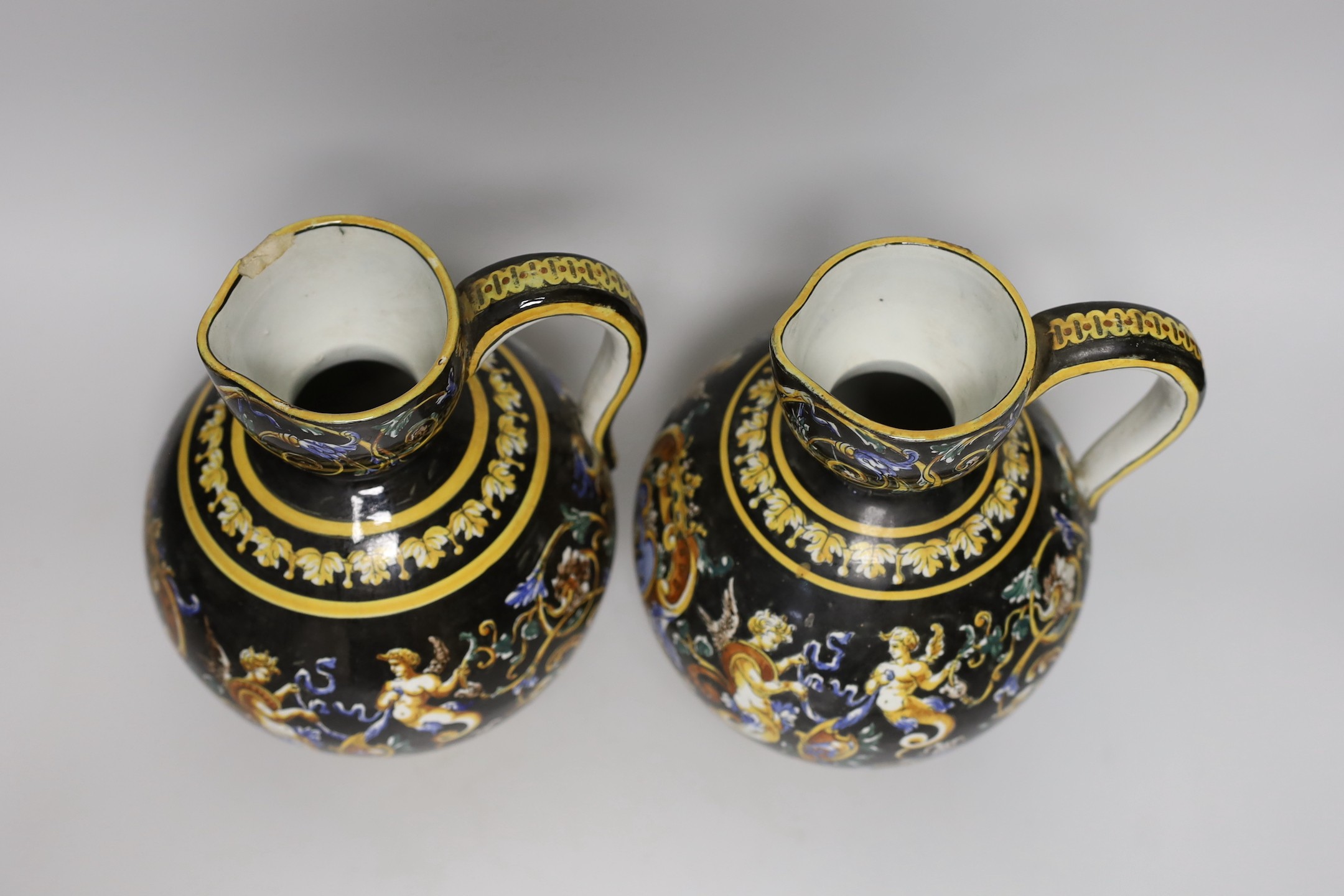 A pair of French maiolica ewers, 22cms high